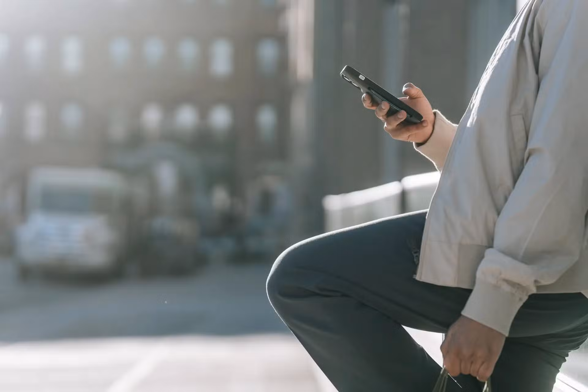 Osoba trzymająca smartfon na ulicy miasta